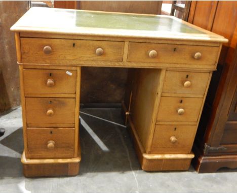 Light oak pedestal desk with inset leather writing surface, two frieze drawers with three further short drawers to either sid