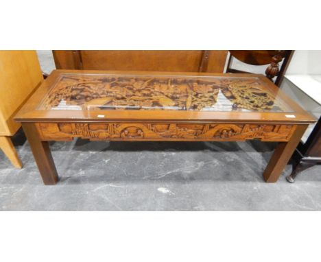 Chinese coffee table of rectangular form with a central panel carved in deep relief with figures, with glazed top, 122cm long