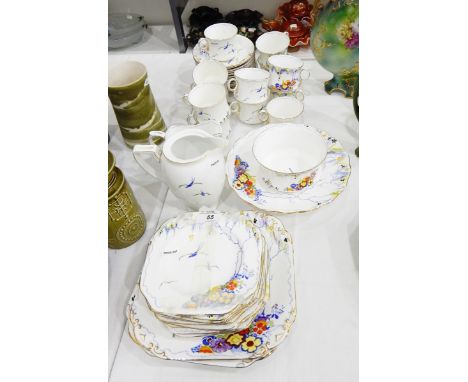 Carltonware bone china part tea service on white ground with printed blue stylised design with enamel flowers, trees and swal