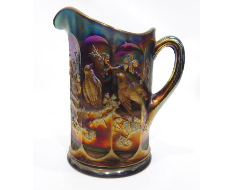 Collection of amethyst carnival glass including a comport with moulded decoration of butterflies, a panel-sided jug decorated