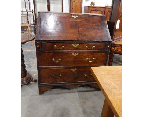 Georgian oak bureau, the fall-front enclosing a fitted interior of small drawers and pigeonholes, three long graduated drawer