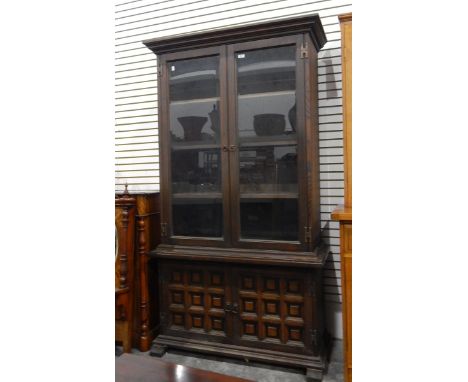 Glazed bookcase with pair of panel doors doors enclosing shelves, pair of panelled cupboard doors below, on block feet, width