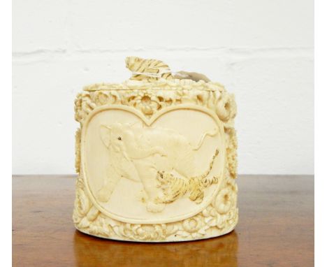 Late 19th c. /early 20th c. Japanese carved ivory tusk box, oval and lidded having elephants and tigers in two reserves, the 