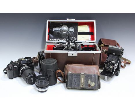 A collection of assorted cameras, lenses and accessories, including Nikon F-300 camera with Zoom-Nikkor 35-105mm lens, Olympu