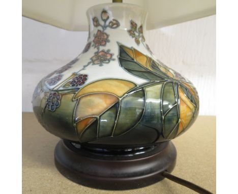 A contemporary Moorcroft table lamp decorated with a design of raspberries and leaves, with fabric shade, and mounted on a wo