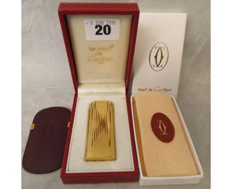 A boxed Cartier gold plated lighter and pouch