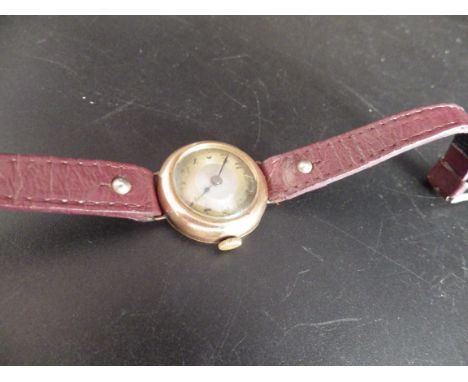 9ct gold 1920's hallmarked watch on a burgandy leather strap,