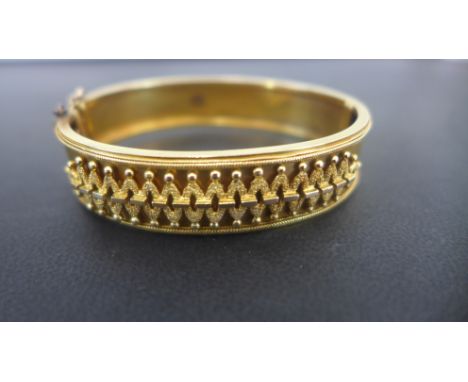 A yellow gold bangle approx weight 16 grams estimated 9ct gold - 65mm x 55mm - overall wear/denting consistent with age