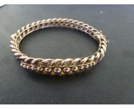 A 9ct gold bangle with curb links over a solid frame and graduated beads - weight approx 14.1 grams - internal diameter 17.5c