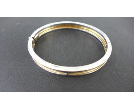 A 14ct white and yellow gold bangle engraved BVLGARI - 7cm x 6cm - approx weight 25 grams - some usage marks, clasp works wel