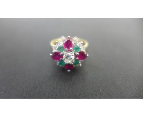 An 18ct yellow gold ruby diamond and emerald cluster ring, the central diamond of approx 0.25ct set with four emeralds and fo