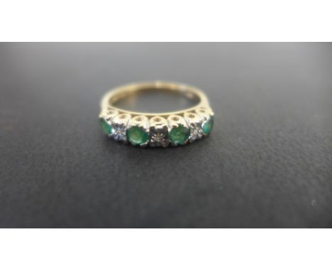 A pretty 9ct yellow gold ring set with four emeralds and three small diamonds in a white gold setting - ring size P - weight 