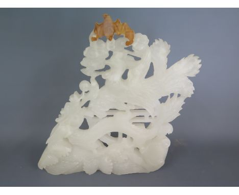 A well carved pale white jade carving with brown inclusions of a dragon and Phoenix and bat on a wave base - 28cm x 24cm in a