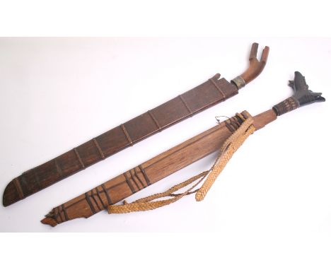 A Borneo Head Hunters Sword Mandau, blade57cms, wooden hilt and scabbard; and an Indonesian parang, swollen blade 56cms, bifu