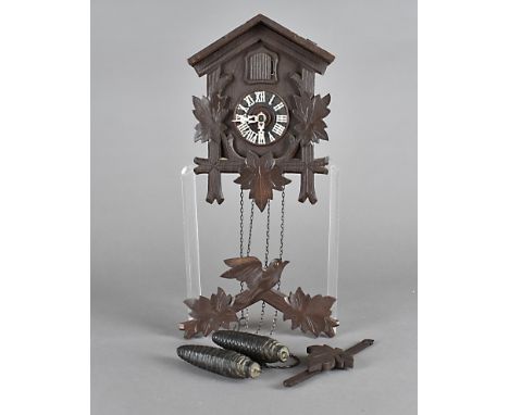 A pre war black forest cuckoo clock, with oak leaf design and pine cone weights 