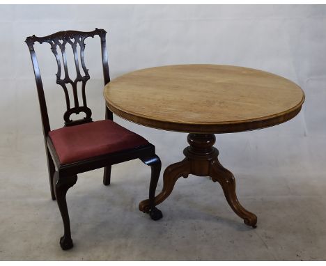 A circular tilt top table, on turned base with tripod legs on porcelain casters, 104cm diameter, together with a pair of chai