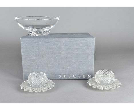 A Steuben glass bowl on a three footed base, in original box together with a pair of cut glass table salts and stands 