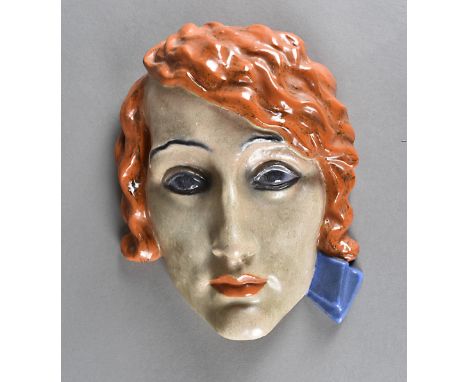 An art deco KWK Keramos Austrian terracotta wall mask, modelled as a fashionable young lady with red hair and blue ribbon, 19