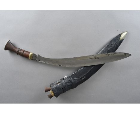 A 1920s Field Officer's issued Kukri, having service leather scabbard with white metal tip, two skinning knives, wooden handl