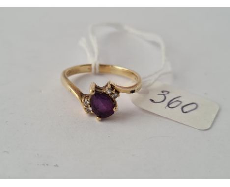 An amethyst cross over ring in 9ct - size O.5 - 2.6gms