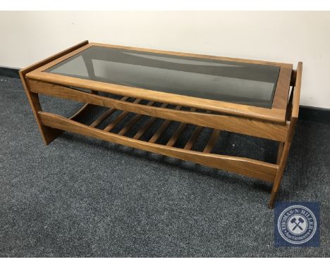 A late twentieth century teak glass topped coffee table with under shelf 