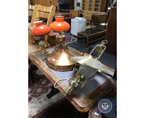 A brass light fitting in the form of an oil lamp, copper light shade and two brass oil lamps with shades converted into table