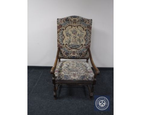 A continental oak scroll arm armchair upholstered in a tapestry fabric