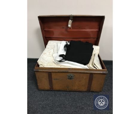 An early twentieth century tin trunk containing bedding and linen, wool blanket, quilt etc 