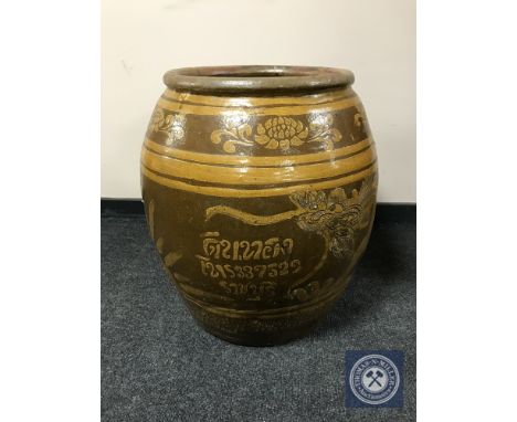 A large glazed earthenware barrel planter 