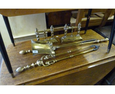 A set of brass fire tools and accompanying brass fire dogs.