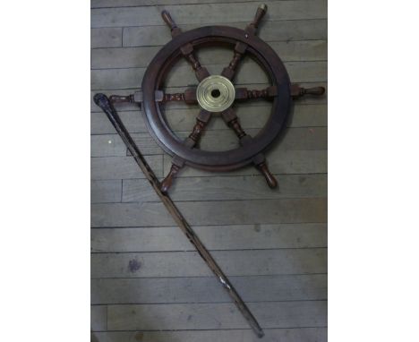 A brass and stained hardwood ship wheels together with a walking stick, the top carved as a man's head (2)