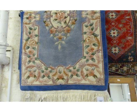 A modern Chinese wool floor rug decorated with flowers on a blue background 