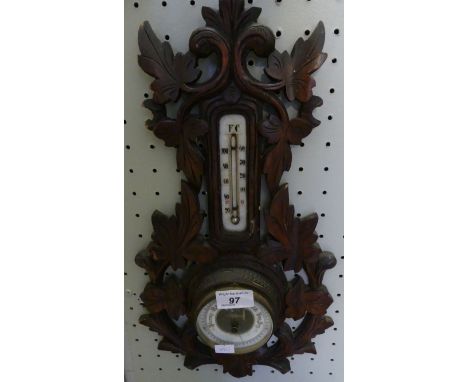 A late 19th Century aneroid barometer/thermometer combination in foliate carved surround.