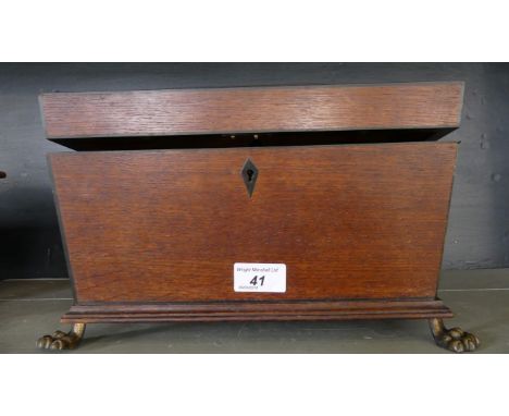 A 19th Century stained oak sarcophagus form tea caddy, the interior with three sections the body raised on small metal paw fe