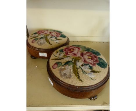 A pair of Victorian tapestry covered footstools of circular form on small ceramic feet (2)