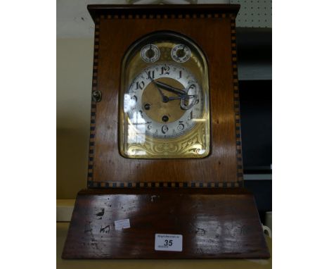 An early 20th Century brass faced mantel clock in later wooden case