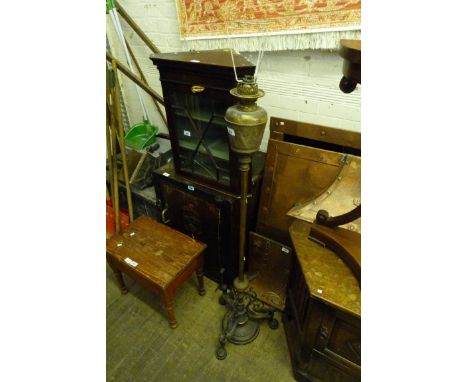 An early 20th Century Gothic revival oil standard lamp, the base having three feet, modelled in the form of mythical beasts.
