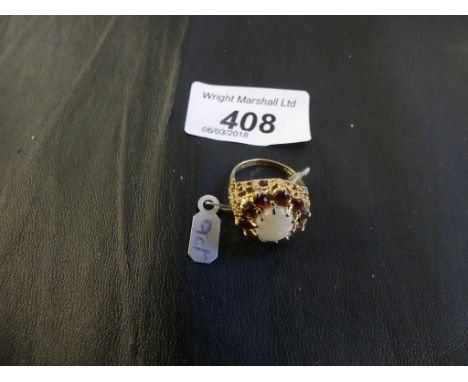 A 9ct gold opal and garnet cluster ring with pierced shoulders, weight 6g.