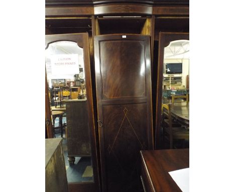 An Edwardian Inlaid Mahogany Break Fronted Triple Wardrobe, The Centre Section with three Slides Two Drawers and A Shelf Flan