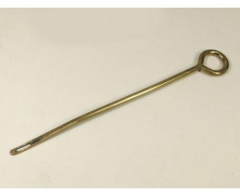 MILITARY TOOL. A long solid brass 'needle', one end bearing a broad arrow mark above a faintly impressed anchor. The other en