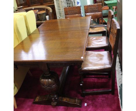 An oak drawer leaf dining table together with four leather single chairs