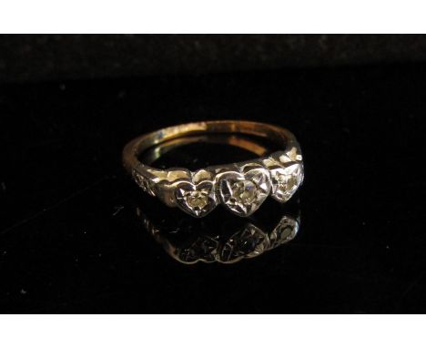 A gold platinum set three stone diamond ring in heart shaped illusion setting, marks rubbed. Size L, 2.2g 