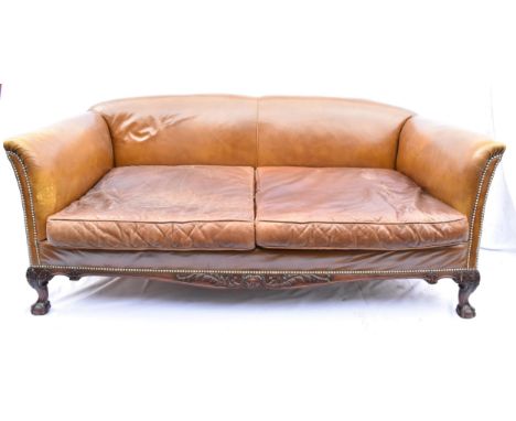 A Howard &amp; Sons, late Victorian mahogany framed leather sofa, with open armrests, rounded back and deep seat, upholstered