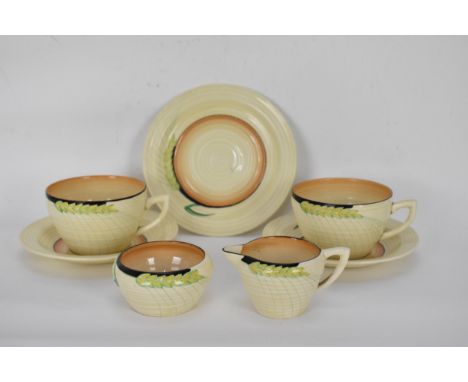 An early 20th century Art Deco Clarice Cliff Wilkinson Wheat design part tea set, comprising two tea cups and saucers, a side