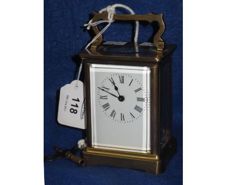 French brass carriage clock with full depth enamel Roman numeral dial and swing handle, with key.  14.5cm high.(B.P. 24% incl