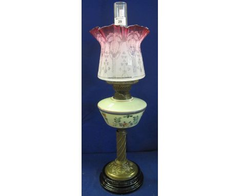Early 20th Century brass double burner oil lamp with ceramic reservoir, brass repousse decorated pedestal and ceramic base wi