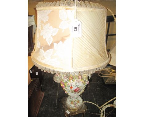 German porcelain florally decorated and encrusted lamp base with gilt metal platform support and vintage shade.(B.P. 24% incl