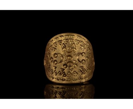 900-1100 AD. Viking age. A large gold ring with a round hoop bearing coiled decoration and a curved elliptical bezel with a b