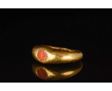 100-300 AD. Roman. A stunning gold wing with a thick, circular hoop and rounded red stone intaglio setting engraved with a be