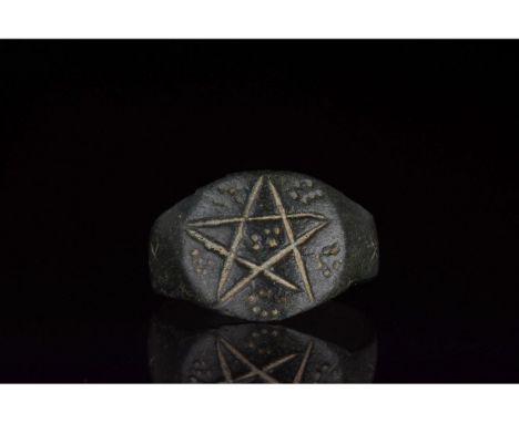 1-200 AD. Roman. Heavy bronze ring with a circular hoop and flattened, rounded bezel bearing an incisded pentagram and dots. 